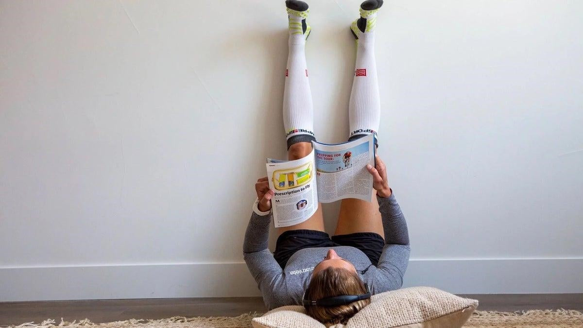 Triathlete recovering after training using compression gear to support recovery and reduce muscle fatigue.