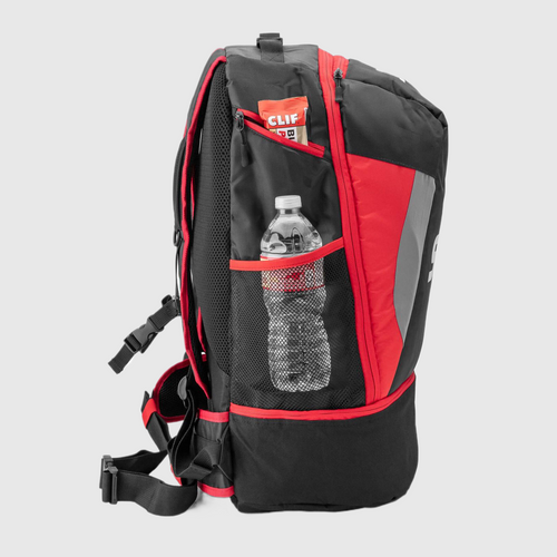 A black and red triathlon backpack with a bottle of water inside