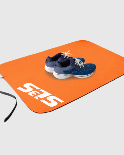 A pair of shoes on an orange transition mat