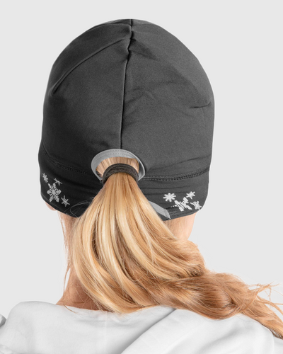 Back view of a woman wearing a black ponytail beanie with snowflake design