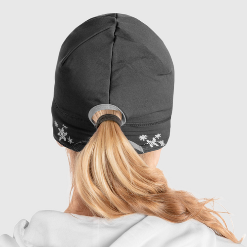 Back view of a woman wearing a black ponytail beanie with snowflake design