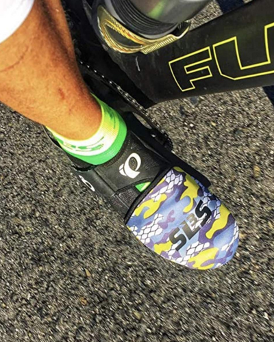 A cyclist's foot in a camo patterned cycling toe covers