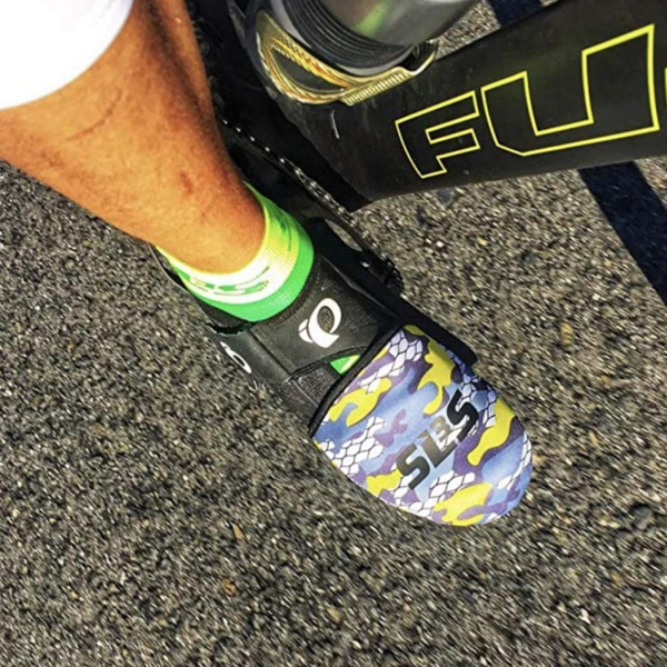 A cyclist's foot in a camo patterned cycling toe covers