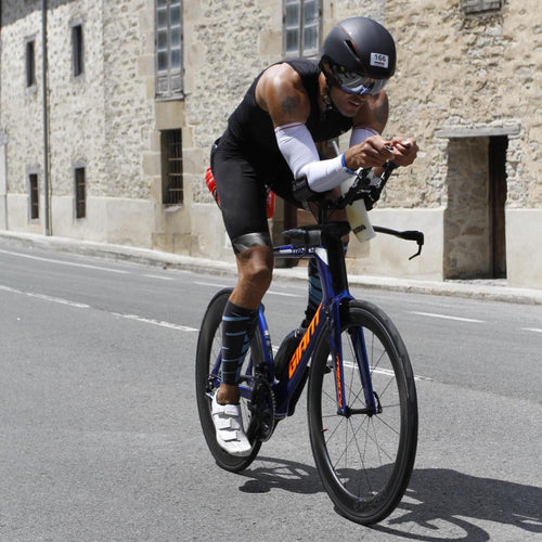 A cyclist riding a time trial bike focused on the road ahead