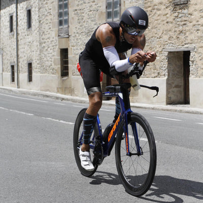 A cyclist riding a time trial bike focused on the road ahead