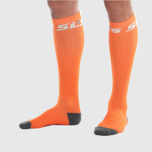 A person wearing bright orange compression socks