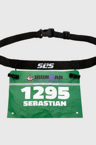 A black adjustable race belt holding a green Ironman race bib