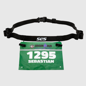 A black adjustable race belt holding a green Ironman race bib