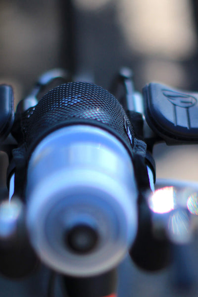 Close-up of a bicycle handlebar with a water bottle attached to it