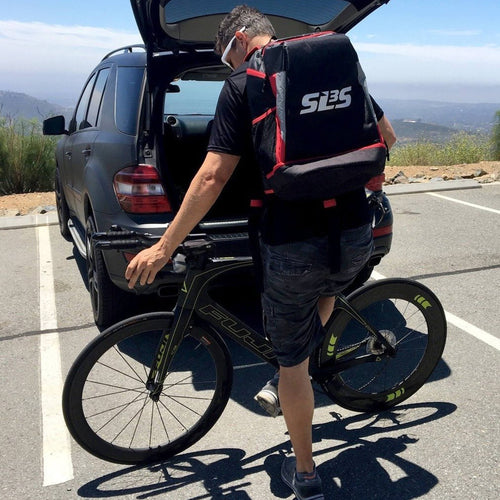 A person wearing a backpack with a bicycle in the back of his car