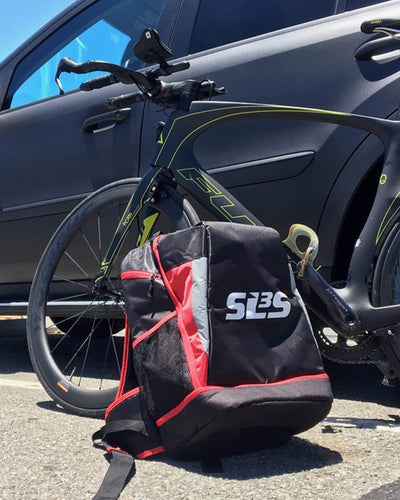 A bicycle, a triathlon backpack, and a car