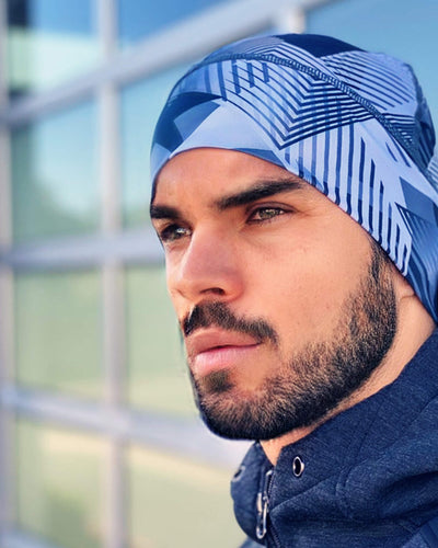 Profile view of a man wearing a blue patterned runnie beanie