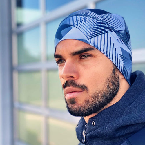 Profile view of a man wearing a blue patterned runnie beanie