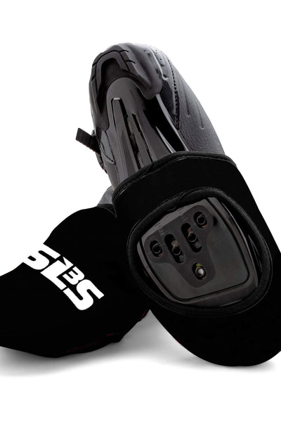 A pair of black cycling toe covers with cycling shoes
