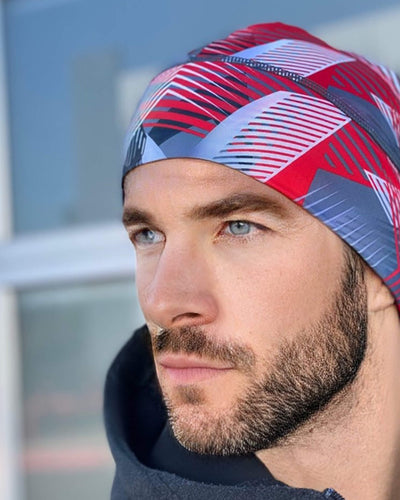 Close-up of a man wearing a red and blue patterned running beanie